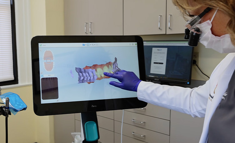 Dentist pointing to a 3D digital intraoral teeth scan displayed on an iTero screen at Rittenhouse Smiles
