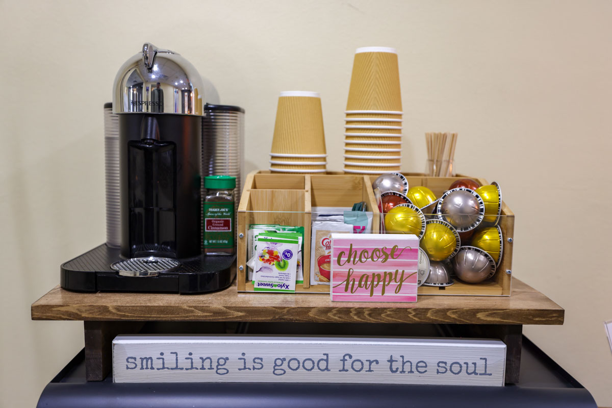 Complimentary patient coffee and beverage station at Rittenhouse Smiles featuring a Nespresso coffee maker, pods, cups, and sweet treats.